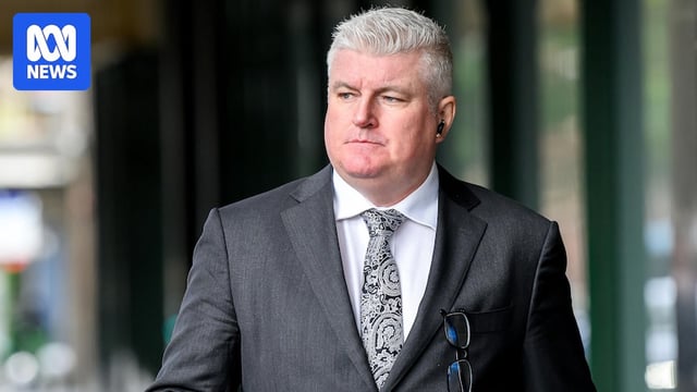 Stuart MacGill wearing a suit outside court
