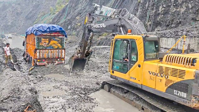 A machine removes mudslide as a truck got stuck following heavy rainfall on Jammu-Srinagar National Highway at Trishul Morh, in Ramban on Thursday. (ANI)