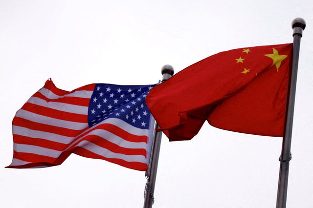 Chinese and U.S. flags flutter outside the building of an American company in Beijing, China April 8, 2025. REUTERS/Tingshu Wang