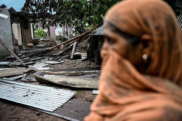 A woman stands outside a house destroyed by Pakistani artillery shelling at the Salamabad village in Uri, about 110kms from Srinagar, on May 8, 2025.
