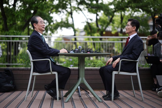 Kim Moon-soo, presidential candidate for South Korea's conservative People Power Party, talks with former Prime Minister Han Duck-soo during a meeting to discuss unifying candidacy in Seoul, South Korea, May 8, 2025.   REUTERS/Kim Hong-Ji/File Photo