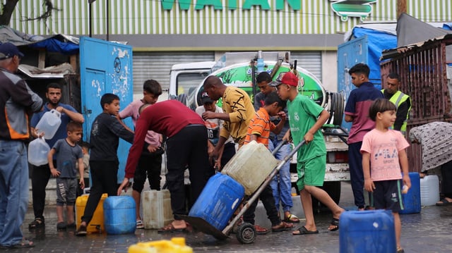 Palästinenser stehen an einer Verteilerstelle im Flüchtlingslager Bureij im zentralen Gazastreifen an, um Wasser nachzufüllen.