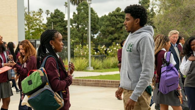 A guy and a girl talk to each other at school