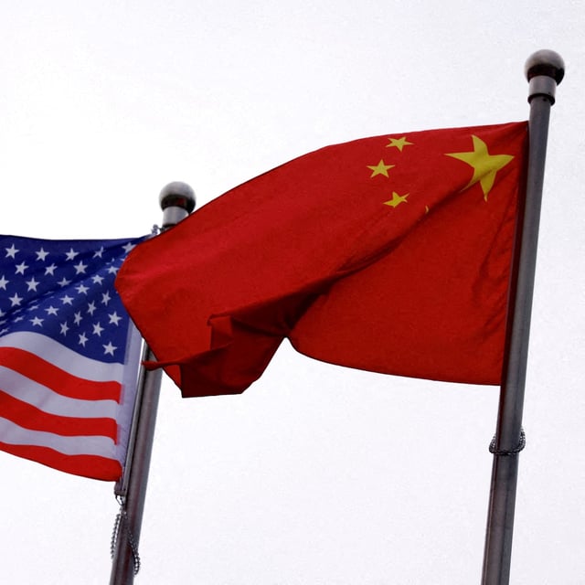 FILE PHOTO: Chinese and U.S. flags flutter outside the building of an American company in Beijing, China April 8, 2025. REUTERS/Tingshu Wang/File Photo