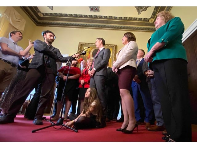 Premier John Hogan takes questions from members of the media Friday, May 9, 2025 while his daughter Maggie looks on from the floor and members of his cabinet surround him. Keith Gosse/The Telegram