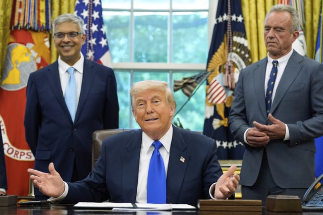President Donald Trump speaks with reporters as he signs executive orders and proclamations in the Oval Office of the White House, Monday, May 5, 2025, in Washington, as Jay Bhattacharya, director of the National Institutes of Health, left, and Health and Human Services Secretary Robert F. Kennedy Jr., listen.