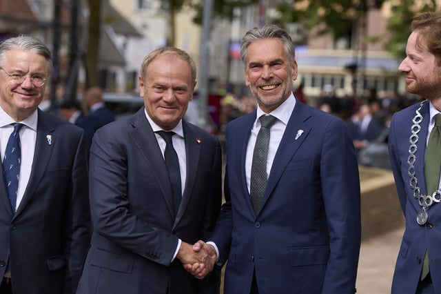Poland's Prime Minister Donald Tusk, center left, is greeted by Netherlands' Prime Minister Dick Schoof, center right, as dozens of World War II veterans gathered for Liberation Day celebrations in Wageningen, Netherlands, Monday, May 5, 2025. (AP Photo/Peter Dejong)