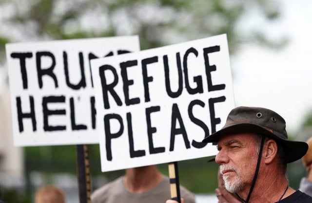 FILE PHOTO: Demonstrators hold placards in support of U.S. President Donald Trump's stance against what he calls racist laws, land expropriation, and farm attacks, outside the American Embassy in Pretoria, South Africa, February 15, 2025. REUTERS/Siphiwe Sibeko/File Photo