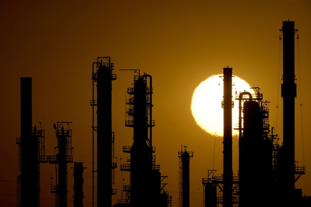 FILE - The CHS oil refinery is silhouetted against the setting sun, Sept. 28, 2024, in McPherson, Kan. (AP Photo/Charlie Riedel, file)