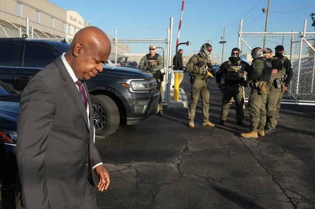 Mayor Ras Baraka of Newark is seen walking past Immigration and Customs Enforcement (ICE) agents standing near a gate to Delaney Hall, a newly converted immigrant detention center, during a protest near the facility in Elizabeth, New Jersey May 7, 2025. (Photo by TIMOTHY A. CLARY / AFP) (Photo by TIMOTHY A. CLARY/AFP via Getty Images)