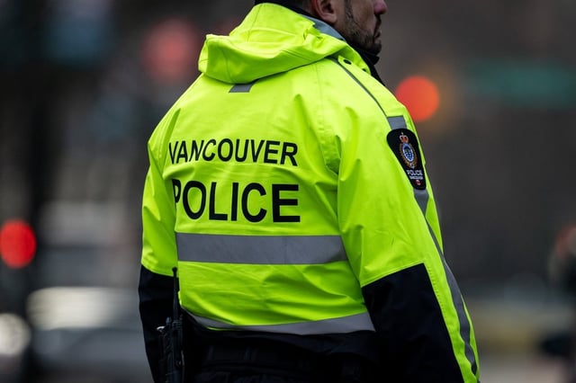 A Vancouver Police officer is pictured in Vancouver on Wednesday, Dec. 4, 2024. A 21-year-old man has been charged in the deaths of two people in Vancouver and Surrey.