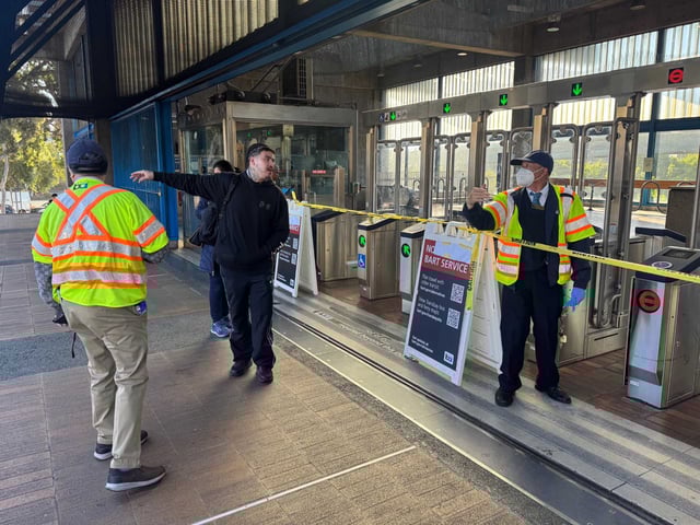 Josiah Aldrich, a barber who works in the Mission, receives directions from station agent Winston O. during the system-wide BART shutdown at the Glen Park BART Station in San Francisco on Friday.