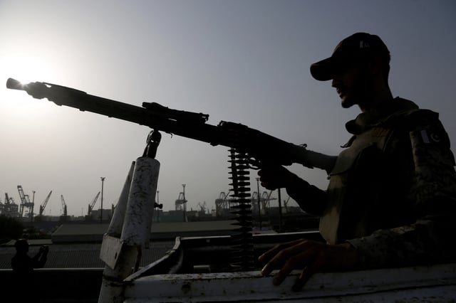 A paramilitary trooper mans a gun atop a vehicle as he keeps guard during a media tour of the Karachi Port, Pakistan, May 9, 2025. REUTERS/Shakil Adil