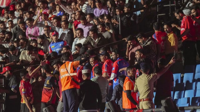 IPL officials and HPCA Stadium security evacuating the cricket ground after a blackout caused play to be abandoned in Dharamsala.