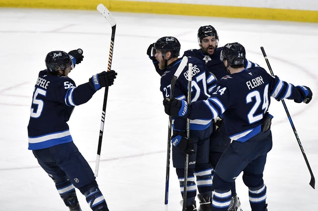 Winnipeg Jets' Nikolaj Ehlers (27) celebrates his goal on the Dallas Stars with Mark Scheifele (55), Haydn Fleury (24) and Dylan Demelo (2) during first period NHL playoff action in Winnipeg, Friday May 9, 2025. THE CANADIAN PRESS/Fred Greenslade