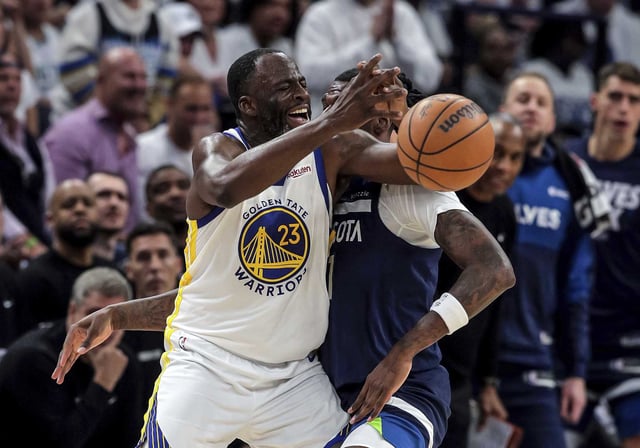 Warriors forward Draymond Green is defended by Minnesota Timberwolves center-forward Naz Reid and gets a technical foul for contact during Game 2 of their second-round playoff series Thursday. 