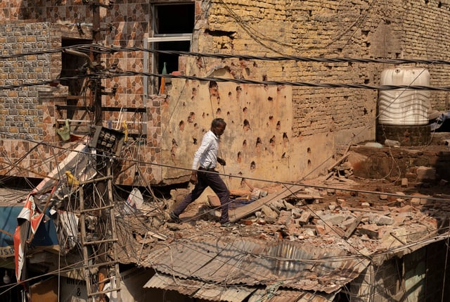 A man walks amidst debris on the roof of a damaged house, following Pakistan's military operation against India, in Rehari, Jammu, May 10, 2025. REUTERS/Adnan Abidi