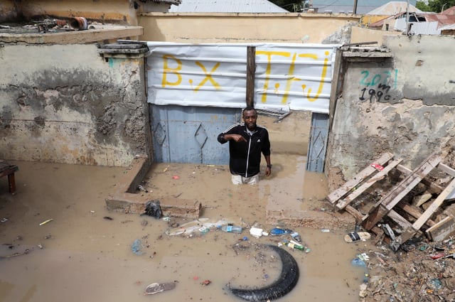 Mohamed Said Haille wades through flood waters, after overnight rains caused damage to houses and infrastructure, in Wadajir district of Mogadishu, Somalia May 10, 2025. REUTERS/Feisal Omar