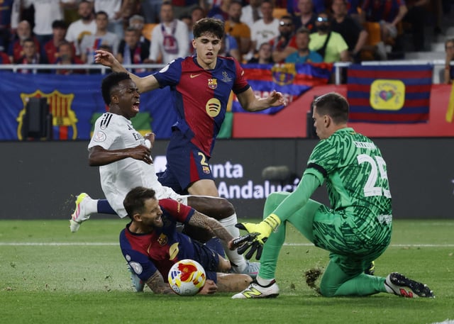Soccer Football - Copa del Rey - Final - FC Barcelona v Real Madrid - Estadio de La Cartuja, Seville, Spain - April 26, 2025 Real Madrid's Vinicius Junior in action with FC Barcelona's Inigo Martinez, Pau Cubarsi and Wojciech Szczesny REUTERS/Marcelo Del Pozo/File Photo