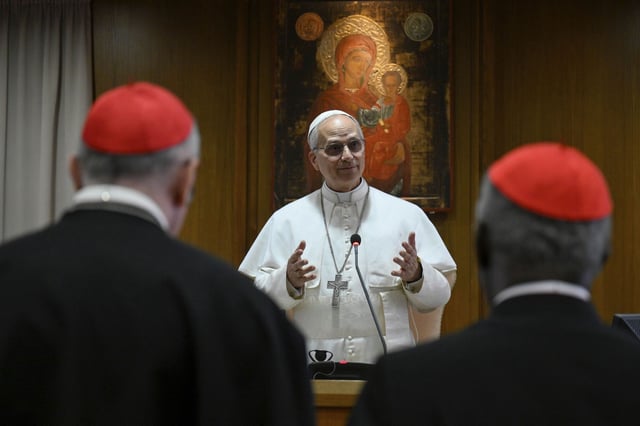Dos cardenales escuchan al papa León XVI durante su discurso al Colegio Cardenalicio.