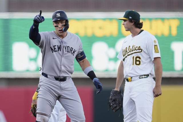 New York Yankees' Aaron Judge, left, reacts next to Athletics first baseman Nick Kurtz (16) after hitting a double during the first inning of a baseball game Friday, May 9, 2025, in West Sacramento, Calif. (AP Photo/Godofredo A. Vásquez)