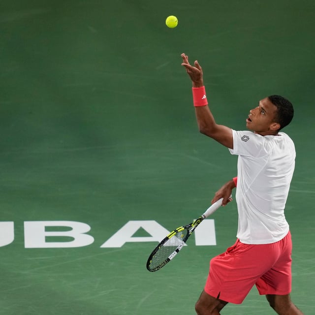 Felix Auger-Aliassime of Canada serves to Stefanos Tsitsipas of Greece during the men's singles final match of Dubai Duty Free Tennis Championship in Dubai, United Arab Emirates, on Saturday, March 1, 2025. (AP Photo/Altaf Qadri)