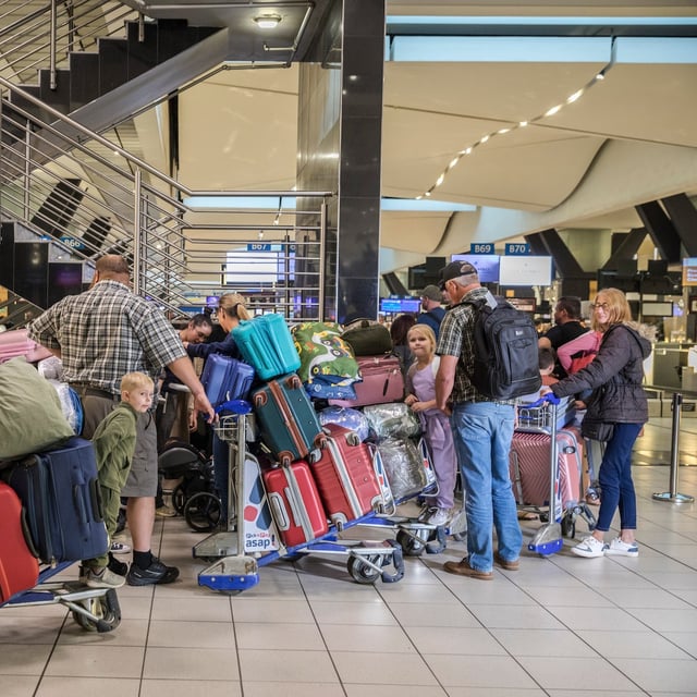 Afrikaner refugees at OR Tambo International Airport in Johannesburg check in for their departure to the United States on Sunday, May 11, 2025. Dozens of Afrikaners who claim discrimination in their home country left Johannesburg on Sunday. Their departure for the U.S. comes as the Trump administration has halted virtually all refugee admissions. (Ilan Godfrey/The New York Times)
