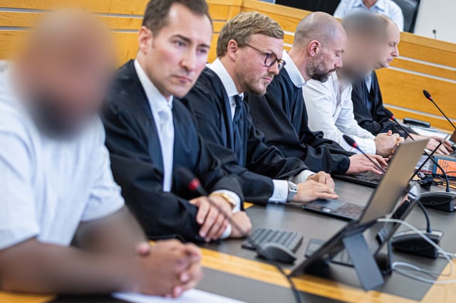 Der angeklagte Staatsanwalt (2.v.r.) und ein weiterer Angeklagter (l.) sitzen zum Auftakt eines Prozesses wegen Bestechlichkeit und Verletzung des Dienstgeheimnisses in einem Saal des Landgerichts Hannover.