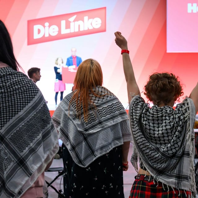 Delegierte mit sogenannten Palästinensertüchern sind auf dem Bundesparteitag der Partei Die Linke in Chemnitz im Saal.