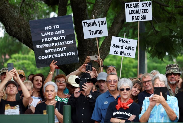 Demonstrators hold placards in support of U.S. President Donald Trump's stance against what he calls racist laws, land expropriation, and farm attacks, outside the American Embassy in Pretoria, South Africa, February 15, 2025. REUTERS/Siphiwe Sibeko/File Photo