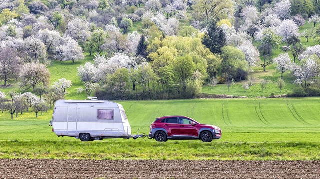 Pkw mit Wohnwagen unterwegs am Albtrauf im Lenninger Tal. 
