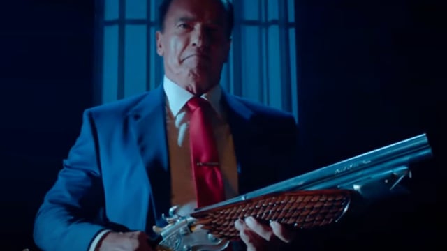 Arnold Schewarzenegger holding a big gun in Kung Fury 2.