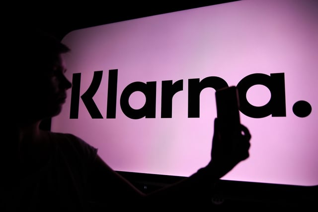 The Klarna logo is visible with a person holding a phone in their hand in Knurow, Poland, on April 20, 2025. (Photo Illustration by Klaudia Radecka/NurPhoto via Getty Images)