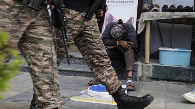 Soldiers patrol as a street vendor takes a nap after India and Pakistan reported no incidents of firing overnight in Srinagar on Monday (AP)