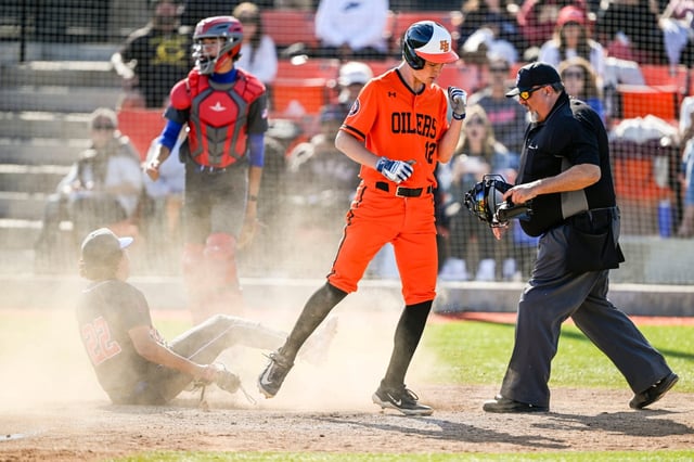 Jared Grindlinger (12) of Huntington Beach reacts when being called safe after scoring on a wild pitch in a Sunset League baseball game against Los Alamitos at Huntington Beach High School in Huntington Beach on Friday, April 18, 2025. (Photo by Leonard Ortiz, Orange County Register/SCNG)