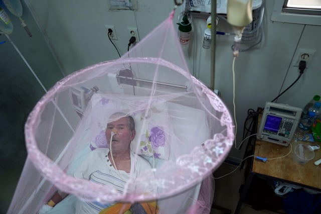 FILE - A patient infected with chikungunya looks out from mosquito netting at the Clinicas Hospital in San Lorenzo, Paraguay, Friday, March 3, 2023. (AP Photo/Jorge Saenz, file)