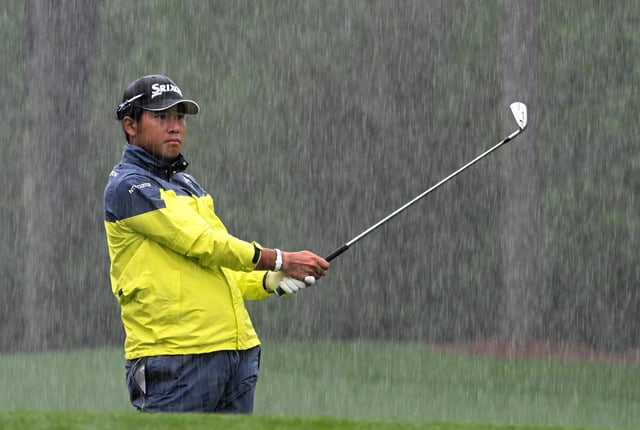 Hideki Matsuyama of Japan on the 12th tee as the rain falls during the third round of the 2023 Masters Tournament at Augusta National Golf Club on April 08, 2023 in Augusta, Georgia.