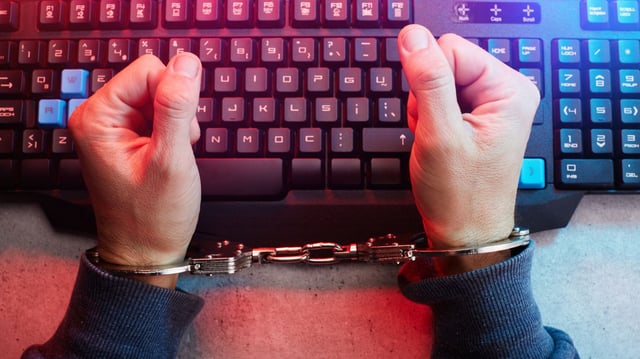 Handcuffed person on computer keyboard, censored journalism, social media censorship concept. Being stuck in a demanding or boring job stock photo