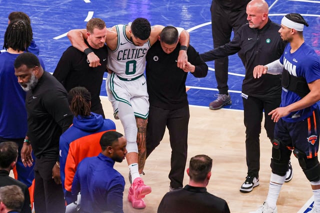 May 12, 2025; New York, New York, USA; Boston Celtics forward Jayson Tatum (0) is helped off the court by after an injury in the second half during game four of the second round for the 2025 NBA Playoffs against the New York Knicks at Madison Square Garden. Tatum would leave the game with an injury after this play. Mandatory Credit: Vincent Carchietta-Imagn Images