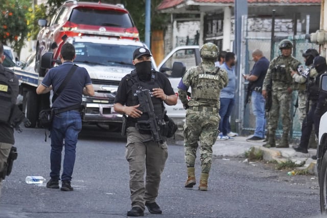 Members of the general prosecutor's office and the Navy stand guard near a vehicle involved in a shootout in Veracruz, Mexico, Monday, May 12, 2025. (AP Photo/Victoria Razo)
