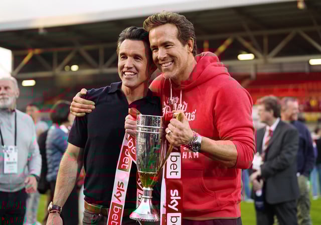 WREXHAM, WALES - APRIL 26: Rob McElhenney and Ryan Reynolds, co-owners of Wrexham AFC, pose for a photo with the trophy following the club&#39;s promotion to the Sky Bet Championship during the Sky Bet League One match between Wrexham AFC and Charlton Athletic FC at Racecourse Ground on April 26, 2025 in Wrexham, Wales. (Photo by Kya Banasko/Getty Images)