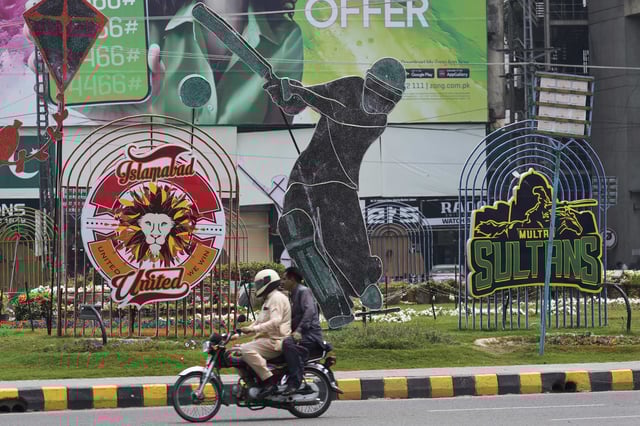 A motorcyclist drives past an advertisement of Pakistan Super League Twenty20 tournament displayed along a roadside in Lahore, Pakistan, Friday, May 9, 2025. (AP Photo/K.M. Chaudary)