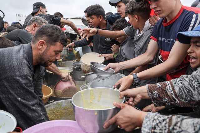 JABALIA, GAZA - MAY 12: A charity organization distributes food and drinking water to Palestinians in the Jabalia area in the north of the Gaza on May 12, 2025. Since March 2, Israel has completely closed its border crossings to humanitarian aid and continued its attacks, while a food crisis persists in Gaza. (Photo by Abdalhkem Abu Riash/Anadolu via Getty Images)