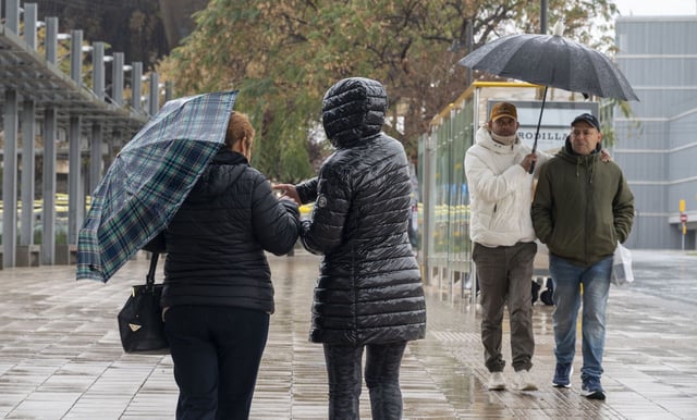 Personas caminando bajo la lluvia.