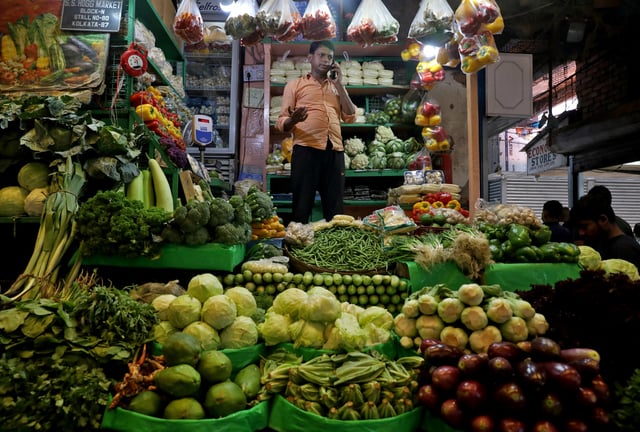 A vegetable vendor speaks on his mobile phone at a retail market area in Kolkata, India, March 22, 2022. REUTERS/Rupak De Chowdhuri/File Photo