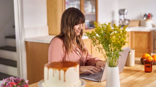 A person looking happy using a Windows 11 laptop