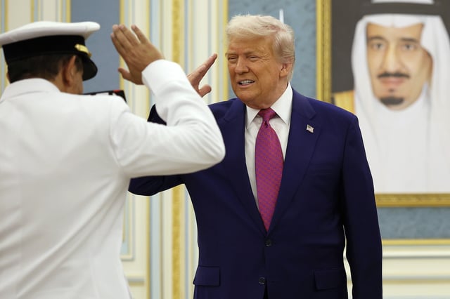 U.S. President Donald Trump and Saudi Crown Prince Mohammed bin Salman (not pictured) interact with officials during a “coffee ceremony” at the Saudi Royal Court on May 13, 2025, in Riyadh, Saudi Arabia.