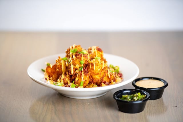 "Loaded Tots," topped with cheese, bacon and green onions is served with "TGI Sauce."
