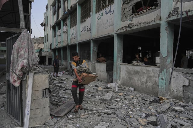 Palestinians inspect the damage at a U.N. school used as a shelter by displaced residents that was hit by Israeli military strikes, killing more than 15 people, in Jabaliya, northern Gaza Strip, on Monday, May 12, 2025. (AP Photo/Jehad Alshrafi)