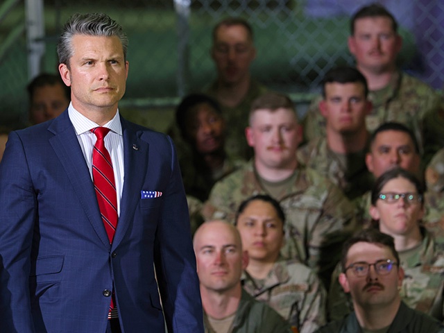 Defense Secretary Pete Hegseth listens as President Donald Trump speaks during a visit with Michigan Air National Guard Troops on April 29, 2025 at Selfridge Air National Guard Base, Michigan. Trump will travel to Macomb Community College in Warren, Michigan to hold a rally where he is expected to highlight his accomplishments during his first 100 days in office, including closing the border, job creation and the economy. (Photo by Scott Olson/Getty Images)